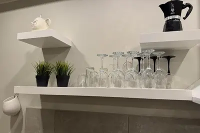 a shelf filled with wine glasses on a wall at Gates of Dawn luxury Apartment - Aušros Vartų apartamentai in Vilnius