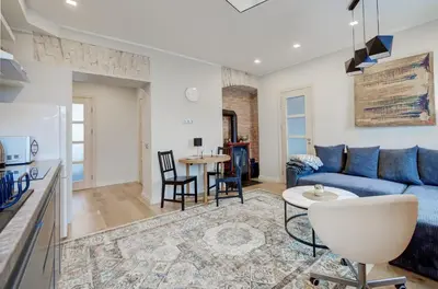 a living room with a blue couch and a table at Gates of Dawn luxury Apartment - Aušros Vartų apartamentai in Vilnius