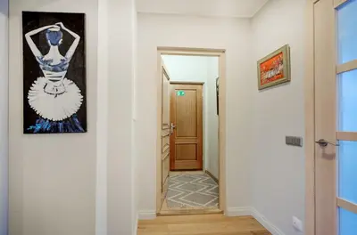a hallway with a door and a painting on the wall at Gates of Dawn luxury Apartment - Aušros Vartų apartamentai in Vilnius