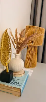 a table with a book and a vase with feathers at Stay in Kaunas LA51A Standard - Free Parking in Kaunas