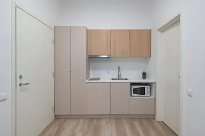 a kitchen with white cabinets and a sink and a microwave at Stay in Kaunas LA51A Standard - Free Parking in Kaunas