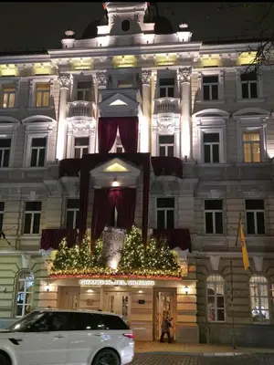 a white car parked in front of a building with christmasreens at K Spot in Old Town with Sauna and Jakuzzi in Vilnius