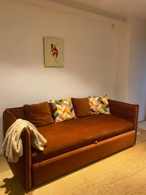 a brown leather couch in a living room at Center Apartment near Hillton with self check-in in Vilnius