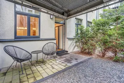 two chairs and a table in front of a house at Center Apartment near Hillton with self check-in in Vilnius