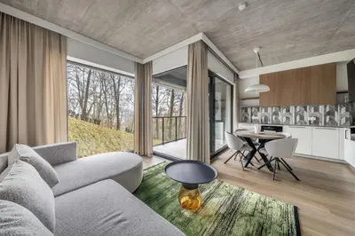 a living room with a couch and a table at 2 Bedroom Green City View apartment by Reside Baltic in Vilnius