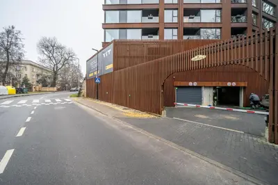 an empty street in front of a building at 2 Bedroom Green City View apartment by Reside Baltic in Vilnius