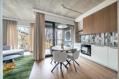 a kitchen and dining room with a table and chairs at 2 Bedroom Green City View apartment by Reside Baltic in Vilnius