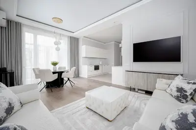 a white living room with a white couch and a table at Luxury apartment Gedimino Pr Downtown with parking in Vilnius