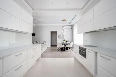 a kitchen with white cabinets and a dining room at Luxury apartment Gedimino Pr Downtown with parking in Vilnius
