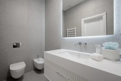 a bathroom with a sink and a toilet and a mirror at Luxury apartment Gedimino Pr Downtown with parking in Vilnius