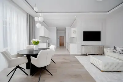 a white living room with a table and chairs at Luxury apartment Gedimino Pr Downtown with parking in Vilnius