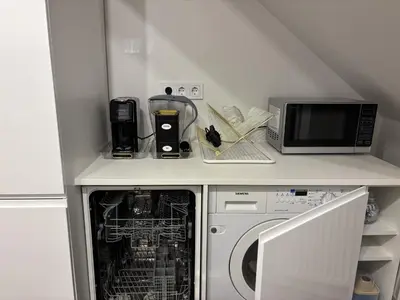 a kitchen with a dishwasher and a microwave on a counter at Centre Modern Elegance Apartment in Kaunas 2026 fully renovated in Kaunas