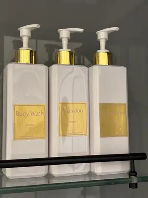 three white bottles of soap on a shelf at Centre Modern Elegance Apartment in Kaunas 2026 fully renovated in Kaunas