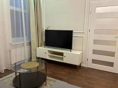a living room with a tv on a white cabinet at Centre Modern Elegance Apartment in Kaunas 2026 fully renovated in Kaunas
