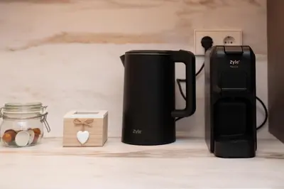 a black coffeemaker sitting on a counter next to a coffee maker at Center Gallery Apartment in Kaunas