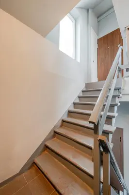 a staircase in a house with white walls and wooden floors at Center Gallery Apartment in Kaunas