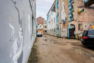 an alley with graffiti on the side of a building at Center Gallery Apartment in Kaunas