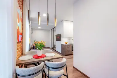 a kitchen and dining room with a table and chairs at Center Gallery Apartment in Kaunas