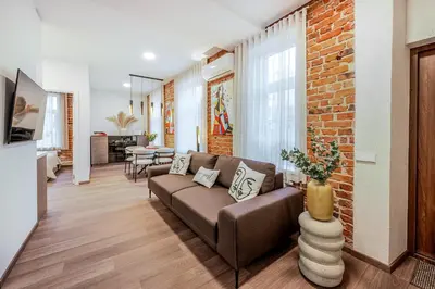 a living room with a couch and a brick wall at Center Gallery Apartment in Kaunas