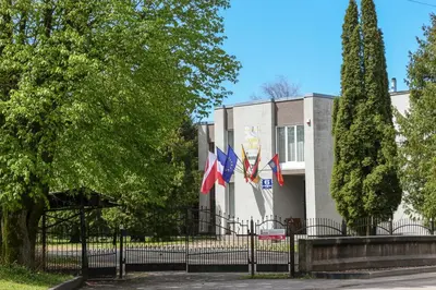 a building with two flags in front of it at Leokordis, UAB in Rokiškis