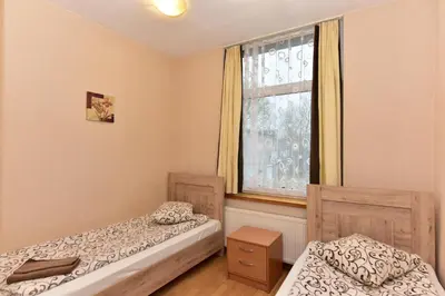 two beds in a room with a window at Leokordis, UAB in Rokiškis