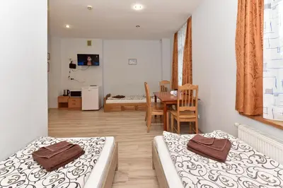 a room with two beds and a dining room with a table at Leokordis, UAB in Rokiškis