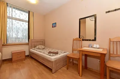 a bedroom with a bed and a table and a mirror at Leokordis, UAB in Rokiškis