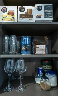 a shelf with wine glasses and other food items at Trumpalaikė butų nuoma Kaune prie Klinikų STUDIJA E SELF CHECK IN in Kaunas