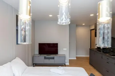 a bedroom with a white bed and a tv at Trumpalaikė butų nuoma Kaune prie Klinikų STUDIJA E SELF CHECK IN in Kaunas