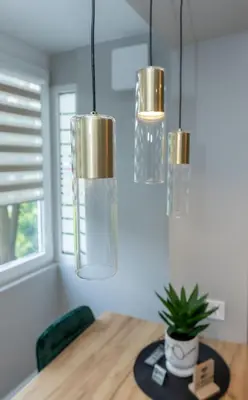 a dining room with three chandeliers hanging over a table at Trumpalaikė butų nuoma Kaune prie Klinikų STUDIJA E SELF CHECK IN in Kaunas