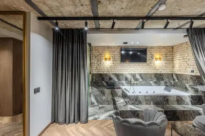 a room with a stone wall and a tub at Basanavičiaus apartament in Vilnius
