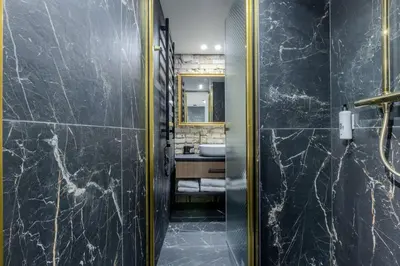 a bathroom with black marble walls and a sink at Basanavičiaus apartament in Vilnius