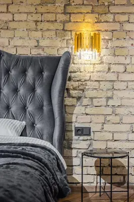 a bedroom with a bed and a brick wall at Basanavičiaus apartament in Vilnius