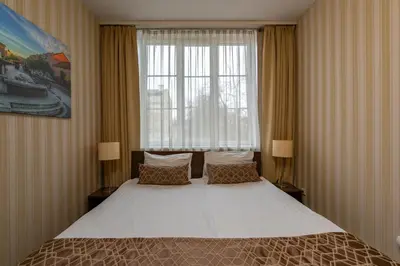 a bedroom with a large bed in front of a window at City Rooms by Lollo Stay in Vilnius