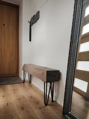 a wooden bench in a room with a mirror at Manere commoda in Šiauliai