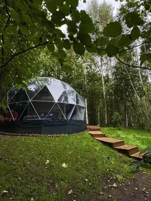 a tent in the middle of a field with stairs at Tyla Dviese in Bendoriai