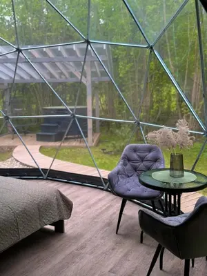 a room with a table and chairs in a glass dome at Tyla Dviese in Bendoriai