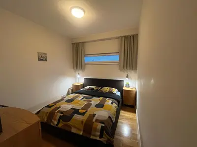 a bedroom with a bed and two night stands and a window at V13 Apartment in Old Town in Vilnius