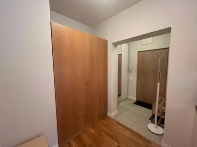 an empty room with a wooden door and a bathroom at V13 Apartment in Old Town in Vilnius