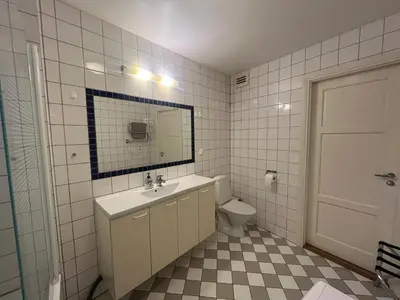 a bathroom with a sink and a toilet and a mirror at V13 Apartment in Old Town in Vilnius