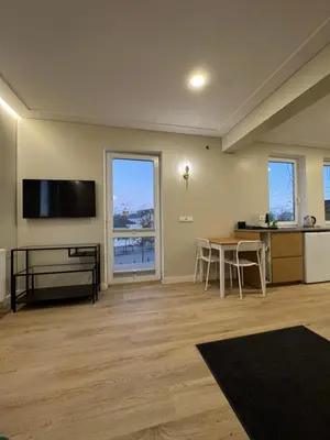 a living room with a flat screen tv and a table at Greenhill in Kaunas