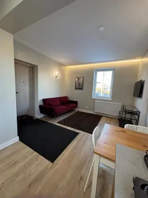 a living room with a red couch and a table at Greenhill in Kaunas