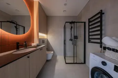 a bathroom with a sink and a shower and a washing machine at Designer Penthouse with Huge Terrace & Fast Wi-Fi in Kaunas