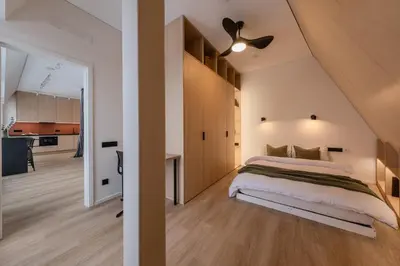 a bedroom with a bed and a ceiling fan at Designer Penthouse with Huge Terrace & Fast Wi-Fi in Kaunas