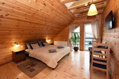a bedroom with a bed in a wooden cabin at Žuvienės Pašiūrė in Rubikiai