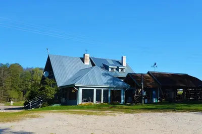 a large blue house with a gambrel roof at Žuvienės Pašiūrė in Rubikiai