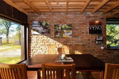 a dining room with a table and a brick wall at Žuvienės Pašiūrė in Rubikiai
