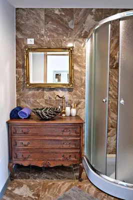 a bathroom with a wooden dresser and a mirror at Sodyba Pušyno kelias