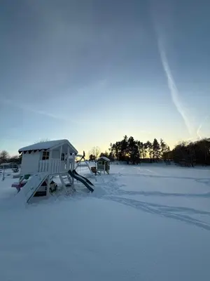 a snow covered field with a house in the snow at Jack namai 2 in Puodžiai