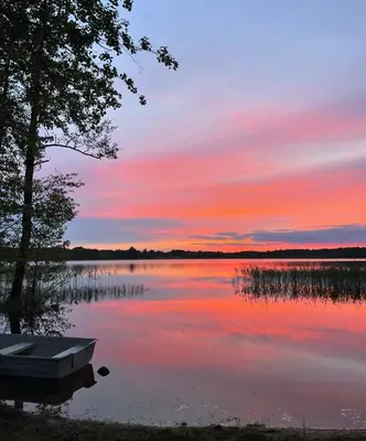a boat on a lake with a sunset at Jack namai 2 in Puodžiai